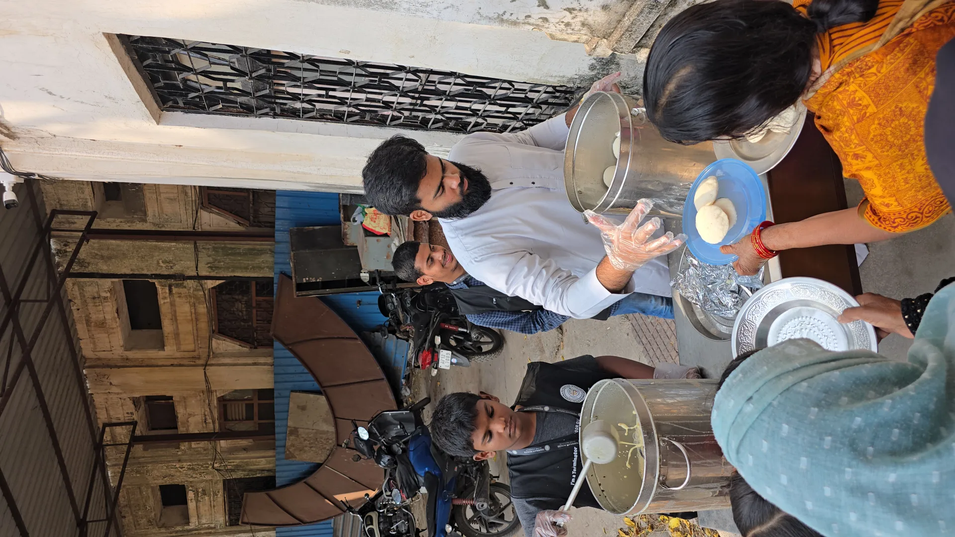 Volunteer serving food at a street distribution